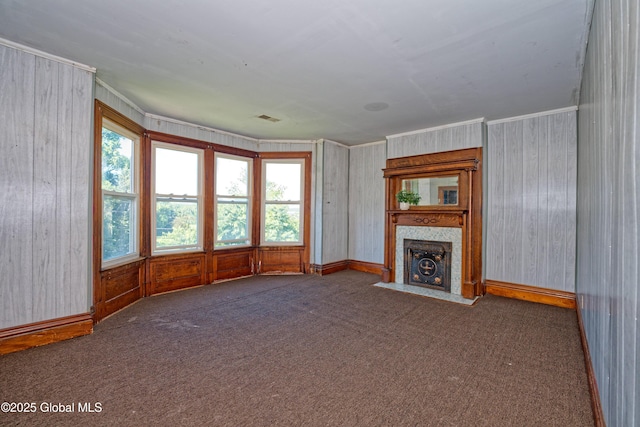 850 Peoples Ave, Troy, NY 12180 - unfurnished living room with healthy amount of natural light, a fireplace with flush hearth, carpet floors, wooden walls, and ornamental molding