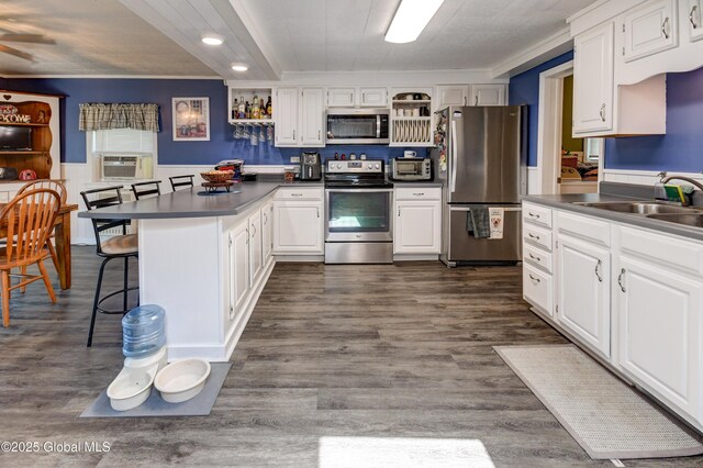 1330 State Highway 67, Johnstown, NY 12095 - kitchen with appliances with stainless steel finishes, open shelves, dark countertops, a peninsula, and wainscoting
