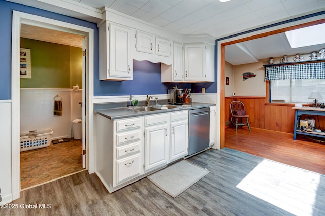 1330 State Highway 67, Johnstown, NY 12095 - kitchen featuring stainless steel dishwasher, wainscoting, wood finished floors, white cabinetry, and a skylight