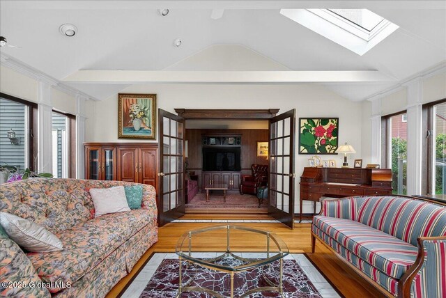 62 Pheasant Ridge Dr, Colonie, NY 12211 - living room featuring french doors, plenty of natural light, vaulted ceiling, wood finished floors, and a skylight