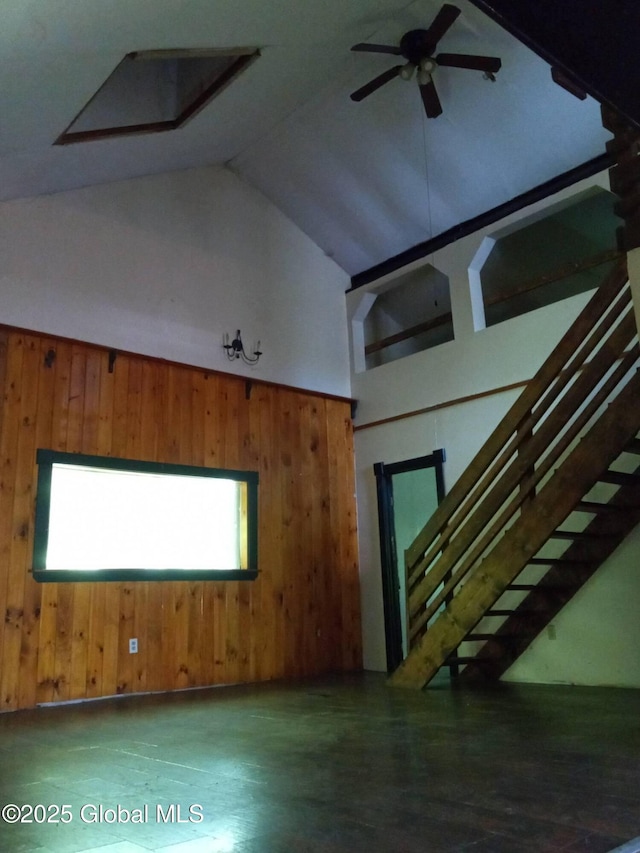 3190 State Highway 10, Johnstown, NY 12095 - unfurnished living room featuring stairs, high vaulted ceiling, wood finished floors, a ceiling fan, and wooden walls