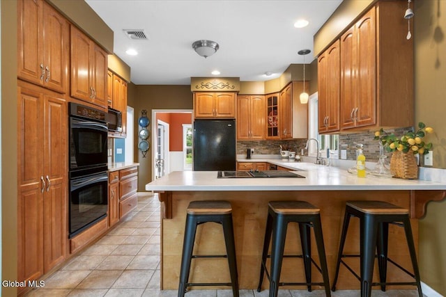 14 Maplecrest Dr, Ravena, NY 12143 - kitchen featuring black appliances, a peninsula, brown cabinetry, glass insert cabinets, and decorative backsplash