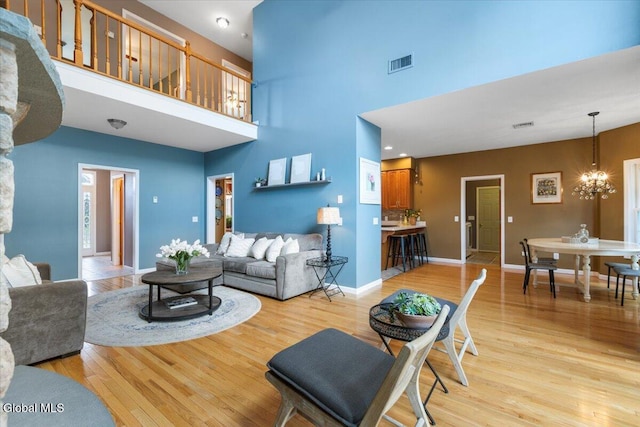 14 Maplecrest Dr, Ravena, NY 12143 - living room featuring a towering ceiling, light wood-type flooring, and a chandelier