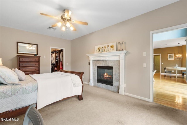 14 Maplecrest Dr, Ravena, NY 12143 - carpeted bedroom featuring a spacious closet, a tiled fireplace, ceiling fan, and a chandelier