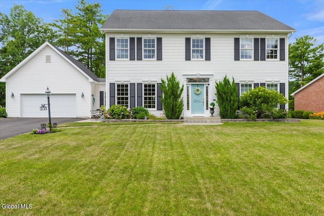 14 Maplecrest Dr, Ravena, NY 12143 - colonial-style house featuring asphalt driveway, a front yard, and an attached garage