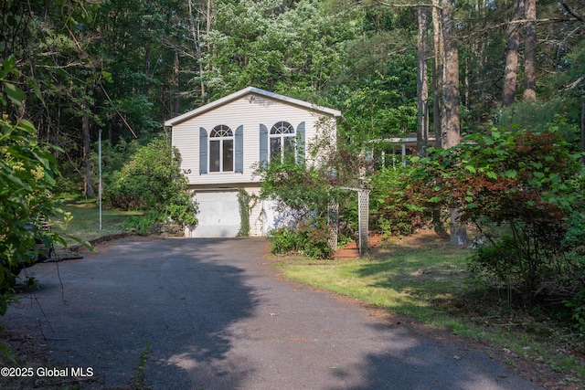 1072 Honey Hollow Rd, New Baltimore, NY 12058 - view of front of house with a garage, driveway, and a wooded view