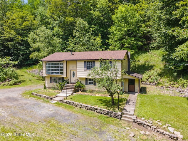 257 Lake Rd, Cobleskill, NY 12043 - raised ranch featuring a front yard, driveway, and a wooded view
