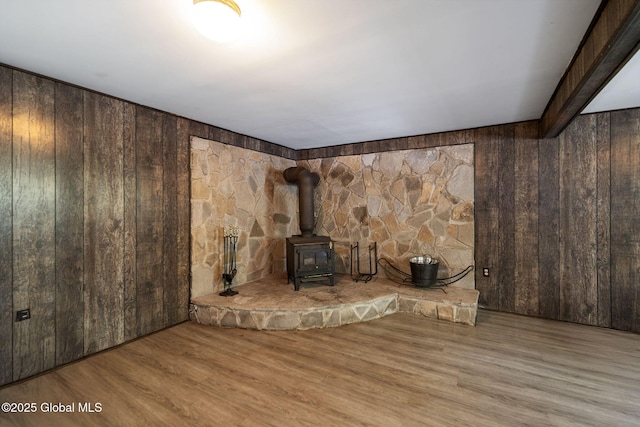 257 Lake Rd, Cobleskill, NY 12043 - unfurnished living room featuring wood walls, a wood stove, and wood finished floors