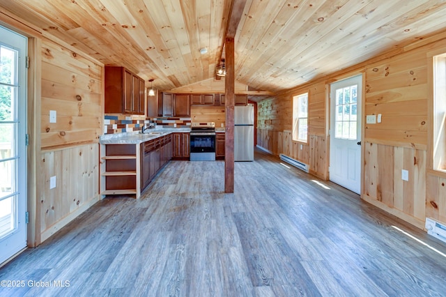 135 Lafayette St, Palatine Bridge, NY 13428 - kitchen featuring appliances with stainless steel finishes, light countertops, light wood-type flooring, wooden walls, and vaulted ceiling