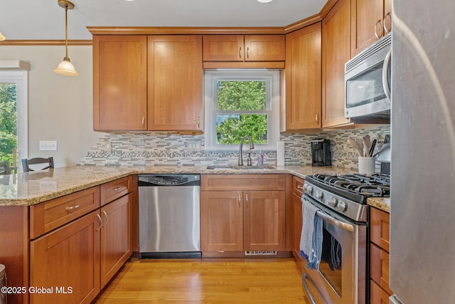 1 Tamarack Ln, East Greenbush, NY 12061 - kitchen with stainless steel appliances, a peninsula, plenty of natural light, brown cabinets, and ornamental molding