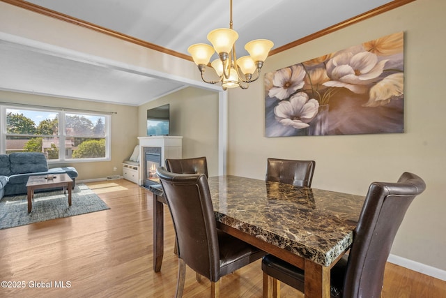 1 Tamarack Ln, East Greenbush, NY 12061 - dining area with crown molding, a chandelier, wood finished floors, and a glass covered fireplace
