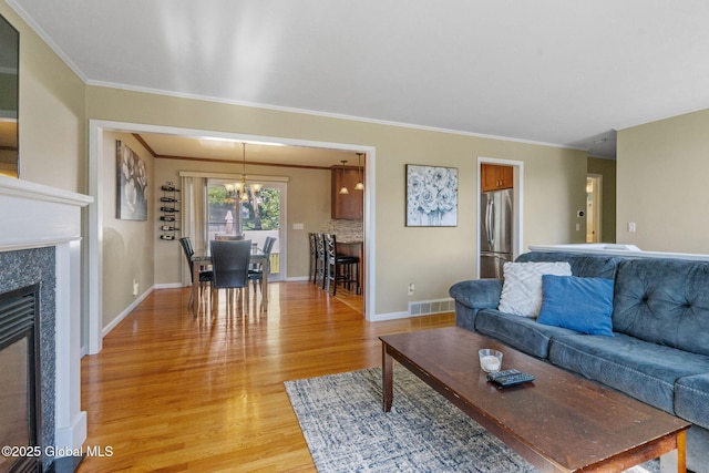 1 Tamarack Ln, East Greenbush, NY 12061 - living room featuring a chandelier, light wood-style flooring, ornamental molding, and a high end fireplace