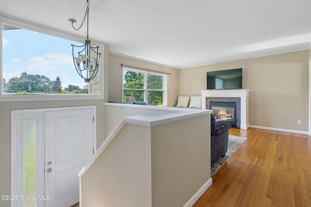 1 Tamarack Ln, East Greenbush, NY 12061 - entryway with light wood-style flooring, a glass covered fireplace, and a chandelier