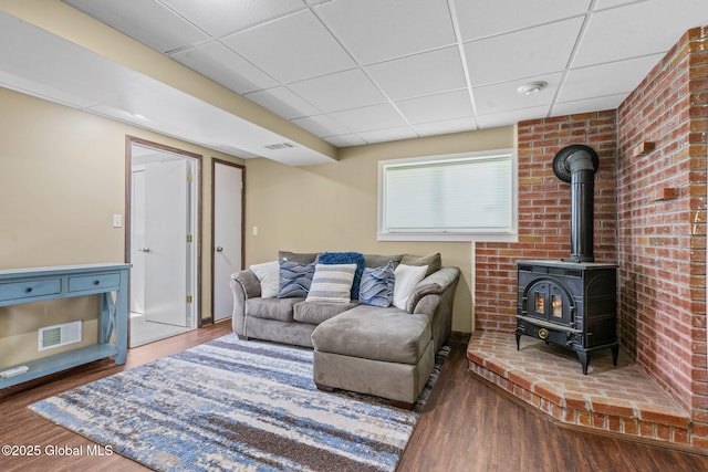 1 Tamarack Ln, East Greenbush, NY 12061 - living area with a paneled ceiling, wood finished floors, and a wood stove