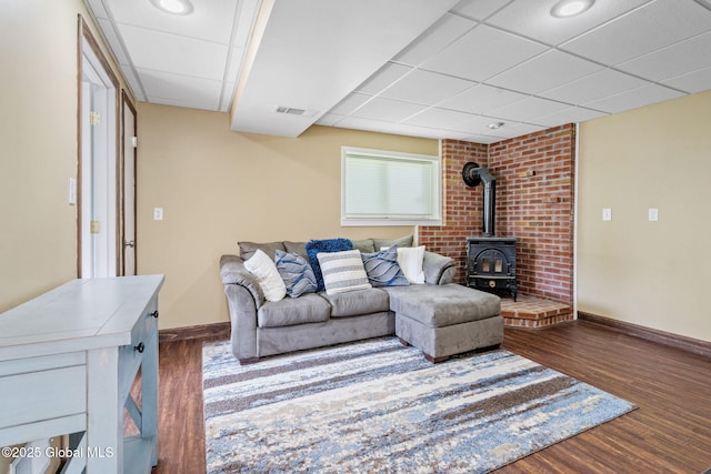1 Tamarack Ln, East Greenbush, NY 12061 - living room featuring a paneled ceiling, a wood stove, and dark wood finished floors