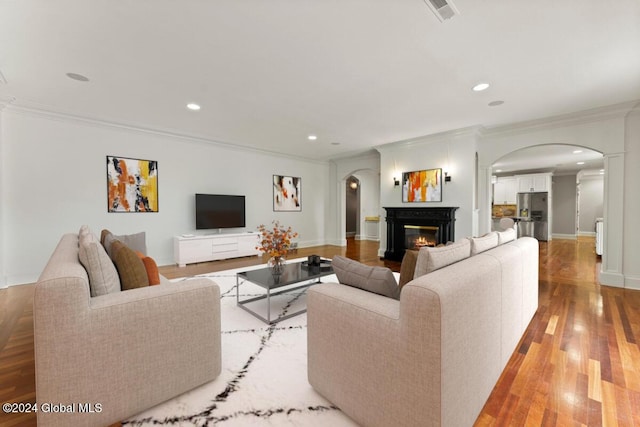 176 5th Ave, Saratoga Springs, Inside, NY 12866 - living room with arched walkways, crown molding, recessed lighting, light wood-style floors, and a glass covered fireplace