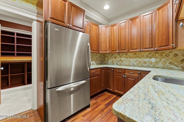 176 5th Ave, Saratoga Springs, Inside, NY 12866 - kitchen featuring freestanding refrigerator, light stone counters, light wood-type flooring, ornamental molding, and tasteful backsplash