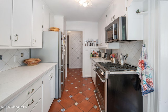 8 Front St, Schenectady, NY 12305 - kitchen with appliances with stainless steel finishes, light countertops, white cabinetry, decorative backsplash, and dark tile patterned floors