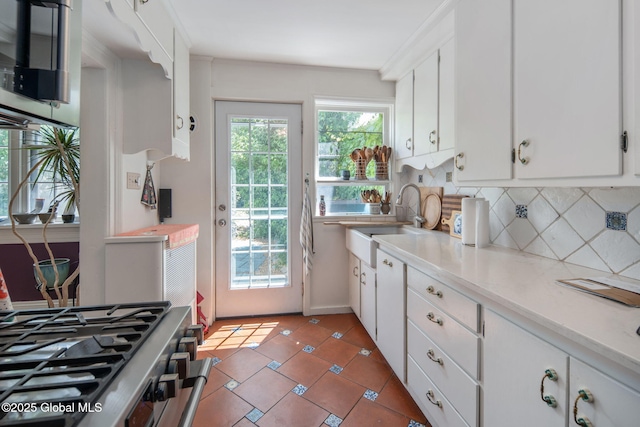 8 Front St, Schenectady, NY 12305 - kitchen featuring backsplash, light countertops, white cabinetry, stove, and light tile patterned flooring