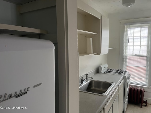302-304 Quail St, Albany, NY 12208 - kitchen with white range with gas stovetop, radiator, open shelves, light countertops, and white cabinets