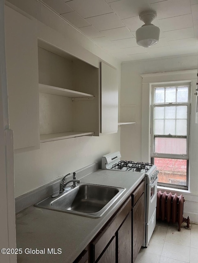 302-304 Quail St, Albany, NY 12208 - kitchen featuring white gas range oven, open shelves, healthy amount of natural light, and radiator heating unit