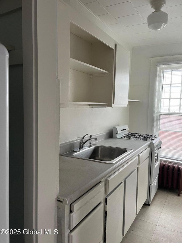 302-304 Quail St, Albany, NY 12208 - kitchen featuring white gas range oven, open shelves, white cabinetry, light countertops, and light tile patterned floors