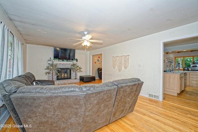 1101 Manas Dr, Schenectady, NY 12303 - living room featuring light wood-style floors, a fireplace, and ceiling fan