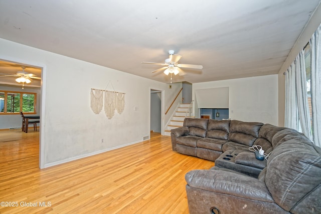 1101 Manas Dr, Schenectady, NY 12303 - living room with a ceiling fan, light wood-style floors, and stairs