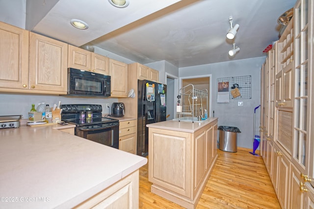 1101 Manas Dr, Schenectady, NY 12303 - kitchen featuring black appliances, light brown cabinets, light countertops, light wood finished floors, and a kitchen island