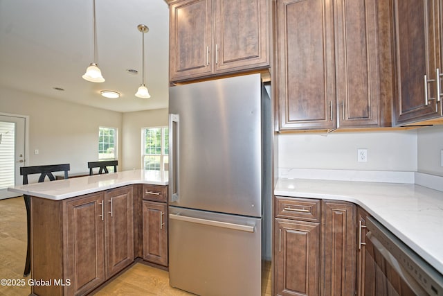 614 Apex Ln, Troy, NY 12182 - kitchen with freestanding refrigerator, dishwashing machine, a peninsula, decorative light fixtures, and light stone countertops