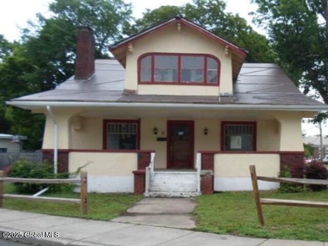 21 Crandall St, Glens Falls, NY 12801 - view of front of property featuring covered porch, stucco siding, and a chimney