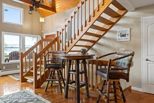 15 Green Harbour Ln, Lake George, NY 12845 - dining space featuring healthy amount of natural light, stairs, wood finished floors, wood ceiling, and a baseboard heating unit