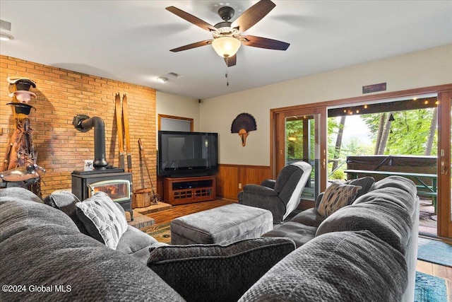 15 Green Harbour Ln, Lake George, NY 12845 - living room with a wood stove, a wainscoted wall, wood finished floors, a ceiling fan, and wood walls