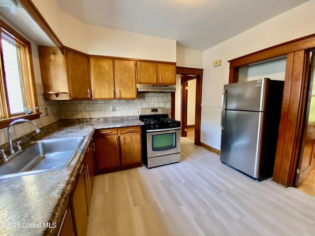 8 Mapleridge Ave, Albany, NY 12209 - kitchen featuring stainless steel appliances, under cabinet range hood, brown cabinets, tasteful backsplash, and light wood-style flooring