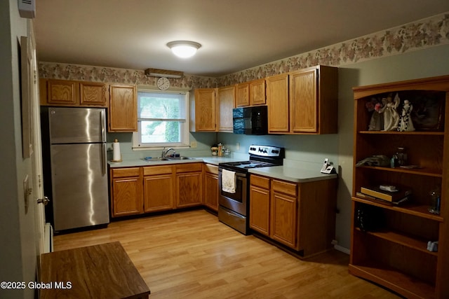 171 Consaul Rd, Colonie, NY 12205 - kitchen featuring appliances with stainless steel finishes, brown cabinetry, light countertops, and light wood-style flooring