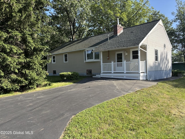 15 Merrill St, Colonie, NY 12205 - view of front facade featuring a chimney, a front yard, roof with shingles, covered porch, and driveway