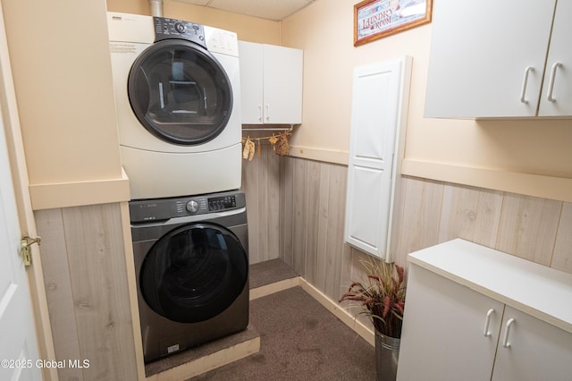 19 Meadow Rd, Hudson Falls, NY 12839 - laundry room featuring stacked washer / dryer, cabinet space, a wainscoted wall, wood walls, and dark colored carpet