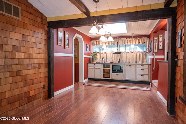 19 Meadow Rd, Hudson Falls, NY 12839 - kitchen featuring beam ceiling, a chandelier, dark wood finished floors, hanging light fixtures, and wooden walls