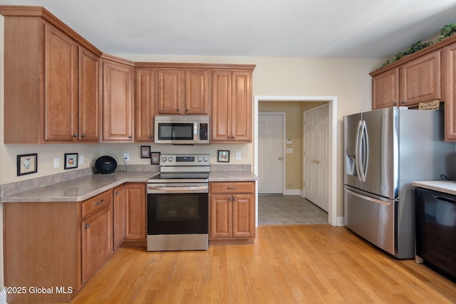 16 Callaway Cir, Colonie, NY 12211 - kitchen featuring stainless steel appliances, light countertops, light wood-style floors, and brown cabinets