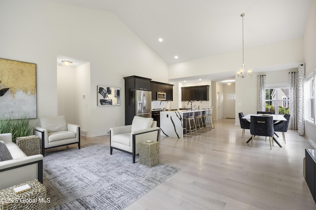10A Idared Ln, Halfmoon, NY 12065 - living area featuring high vaulted ceiling, light wood-type flooring, recessed lighting, and a chandelier