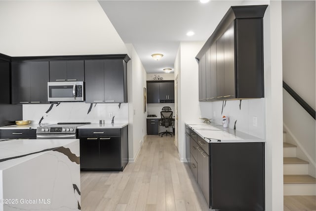 10A Idared Ln, Halfmoon, NY 12065 - kitchen featuring appliances with stainless steel finishes, light wood-style flooring, dark cabinets, backsplash, and recessed lighting