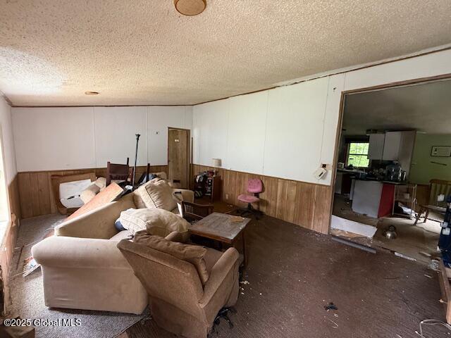 178 E High St, Malta, NY 12020 - living area featuring a wainscoted wall, wood walls, and a textured ceiling