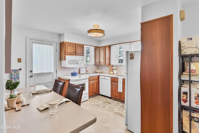 1101 Ardsley Rd, Schenectady, NY 12308 - kitchen featuring white appliances, light countertops, decorative backsplash, and brown cabinets