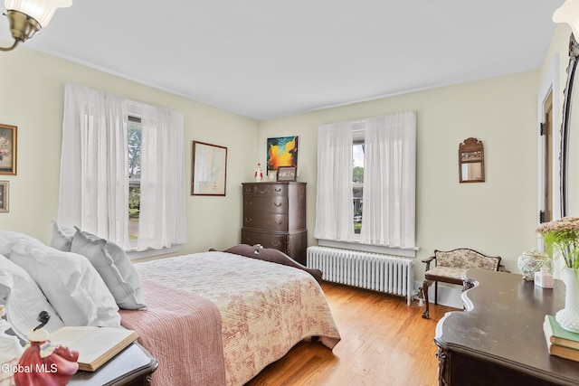 1101 Ardsley Rd, Schenectady, NY 12308 - bedroom featuring radiator heating unit, multiple windows, and wood finished floors