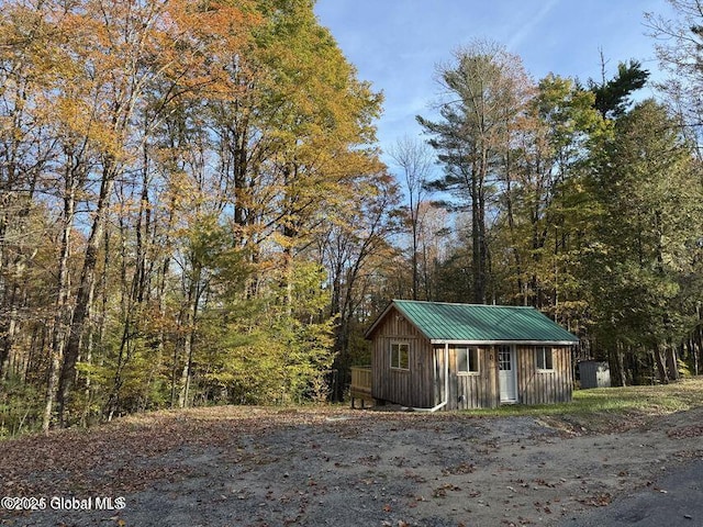 215 Ridge Rd, Minerva, NY 12851 - view of front of house with board and batten siding, an outdoor structure, and a metal roof