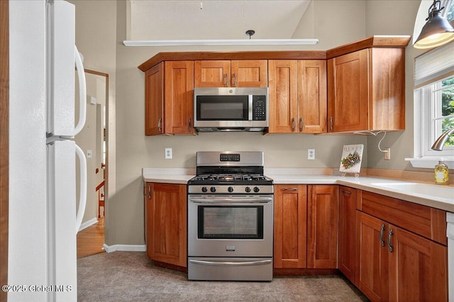 13 Hyland Cir, Troy, NY 12182 - kitchen with appliances with stainless steel finishes, light countertops, brown cabinetry, and light colored carpet