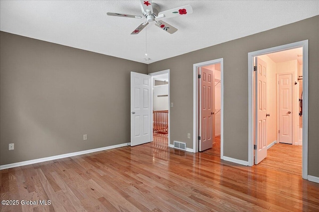 13 Hyland Cir, Troy, NY 12182 - unfurnished bedroom featuring light wood finished floors, a walk in closet, a ceiling fan, and a closet