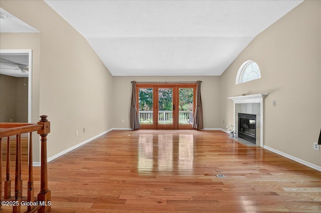 13 Hyland Cir, Troy, NY 12182 - unfurnished living room featuring healthy amount of natural light, light wood-style floors, a tiled fireplace, and high vaulted ceiling