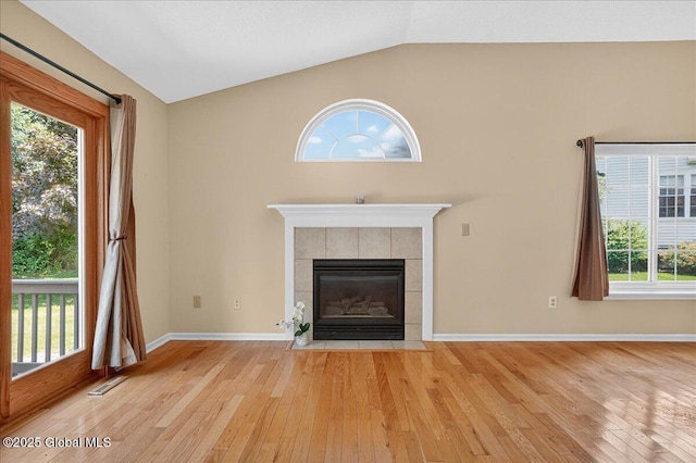 13 Hyland Cir, Troy, NY 12182 - unfurnished living room with light wood finished floors, vaulted ceiling, and a tiled fireplace