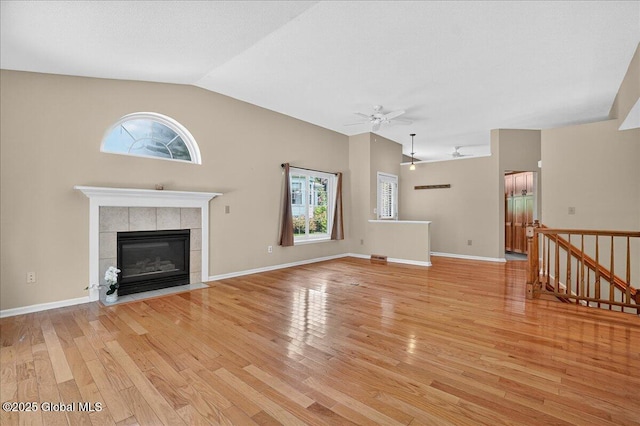 13 Hyland Cir, Troy, NY 12182 - unfurnished living room with a ceiling fan, light wood-style flooring, a fireplace, and vaulted ceiling